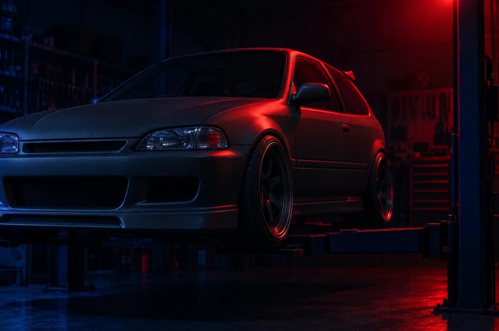 Japanese hot hatch on a workshop hoist under a red key light