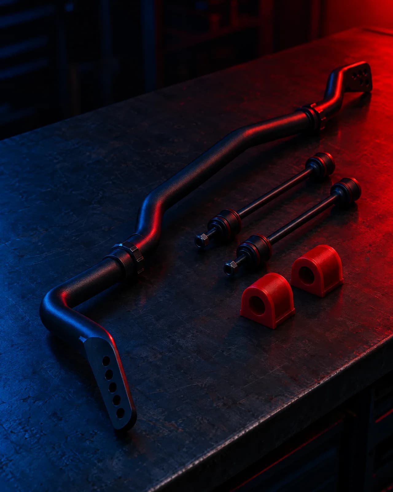 An adjustable rear sway bar with links and polyurethane bushes on a dark bench
