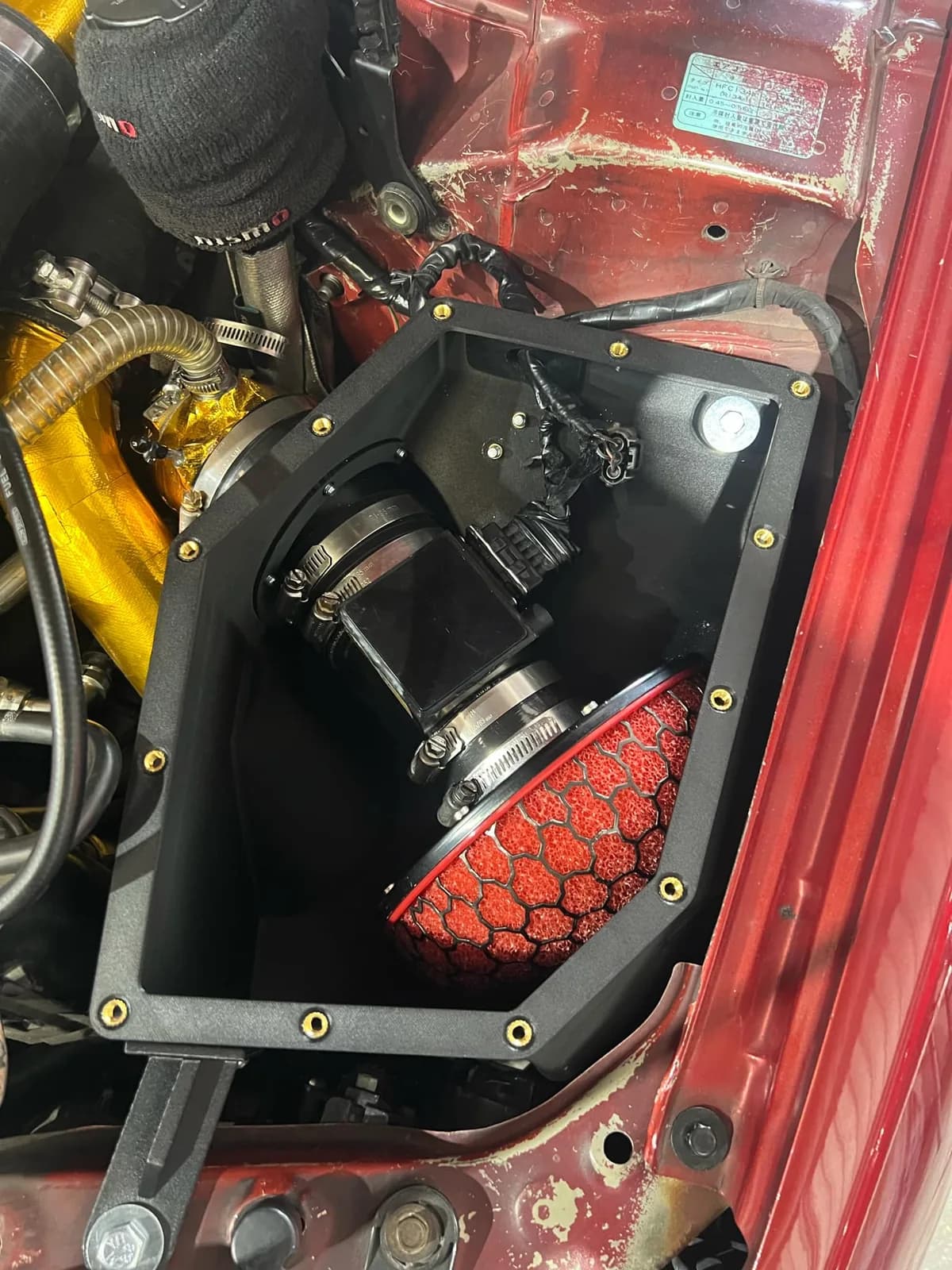 Roccomotive custom R34 GTT airbox with high-flow filter fitted in a red Skyline engine bay
