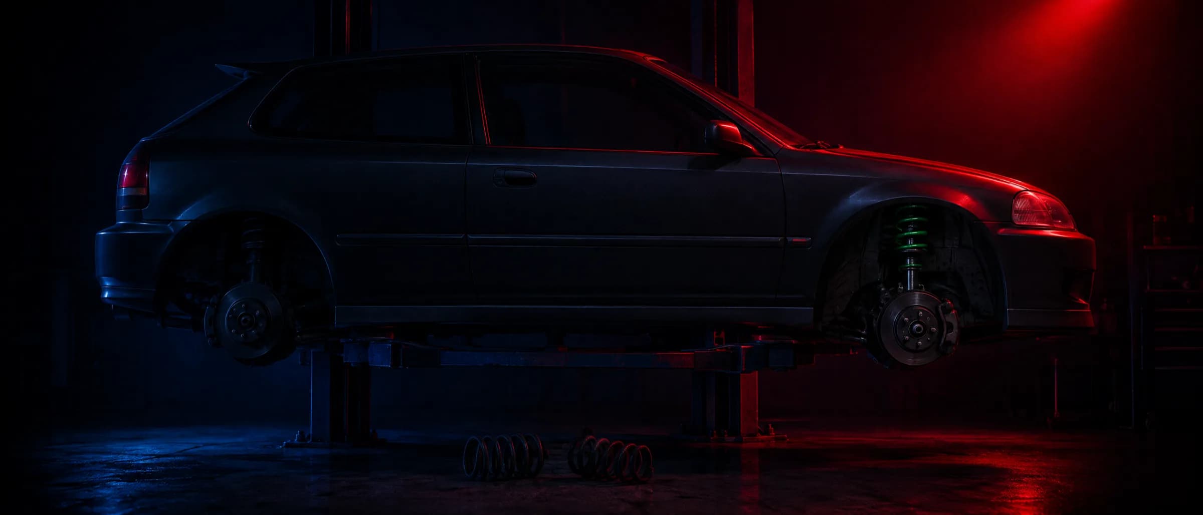 A hatchback on a hoist with new lowering springs fitted, the old springs on the floor